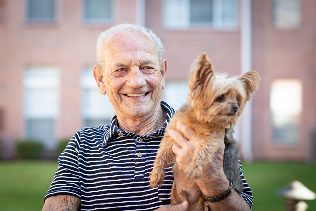 Happy resident holding his dog