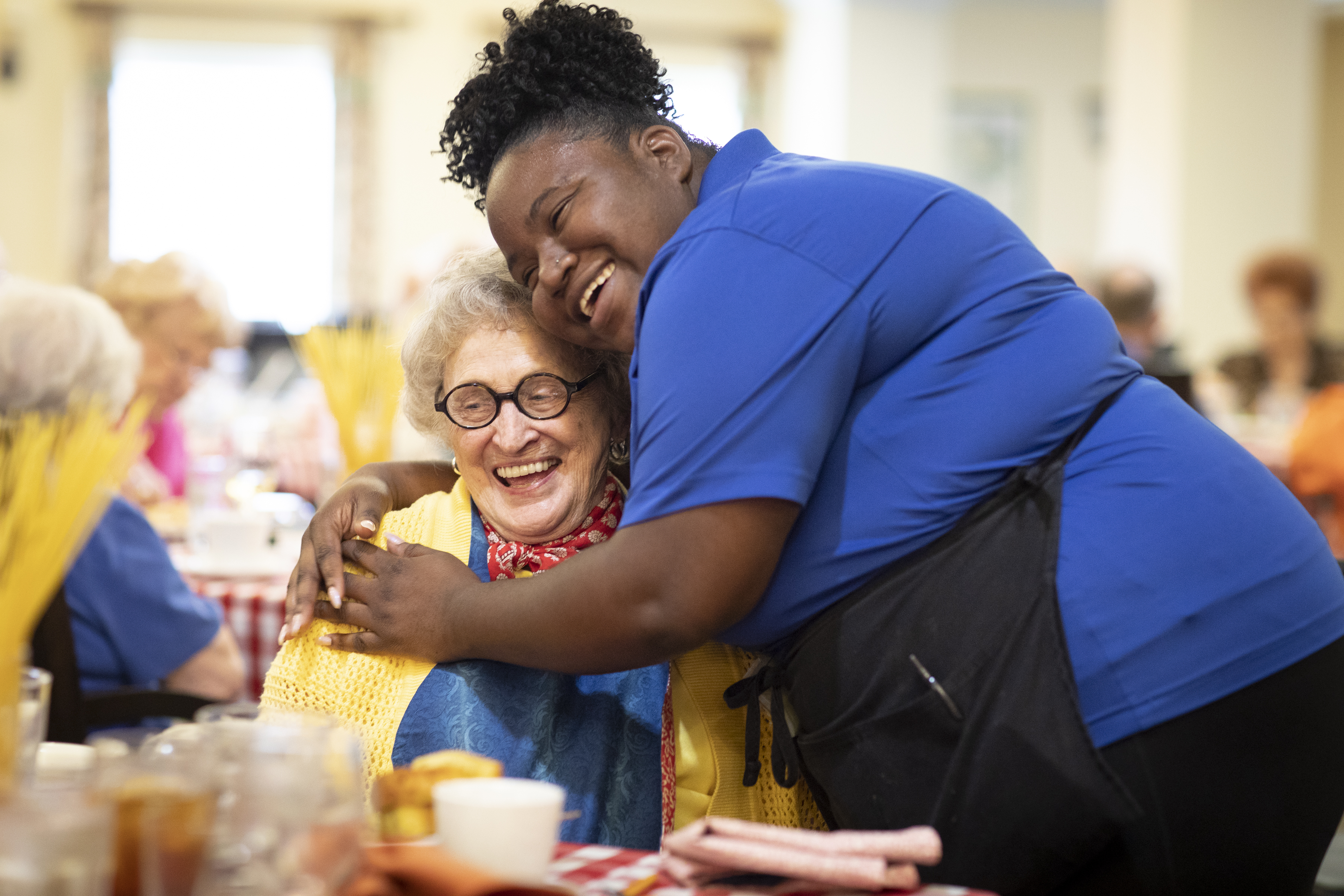 resident and caregiver hugging